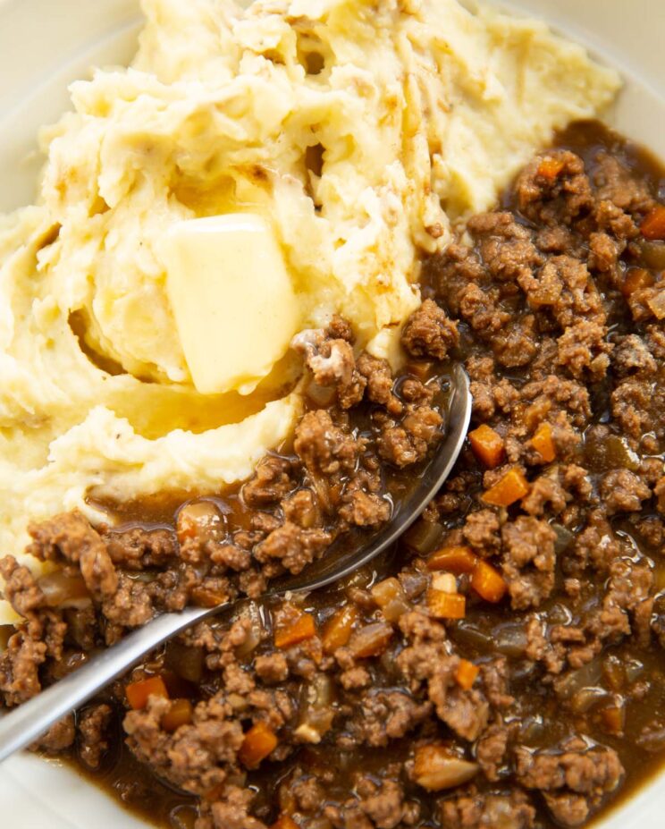 close up shot of silver spoon digging in to mince and tatties