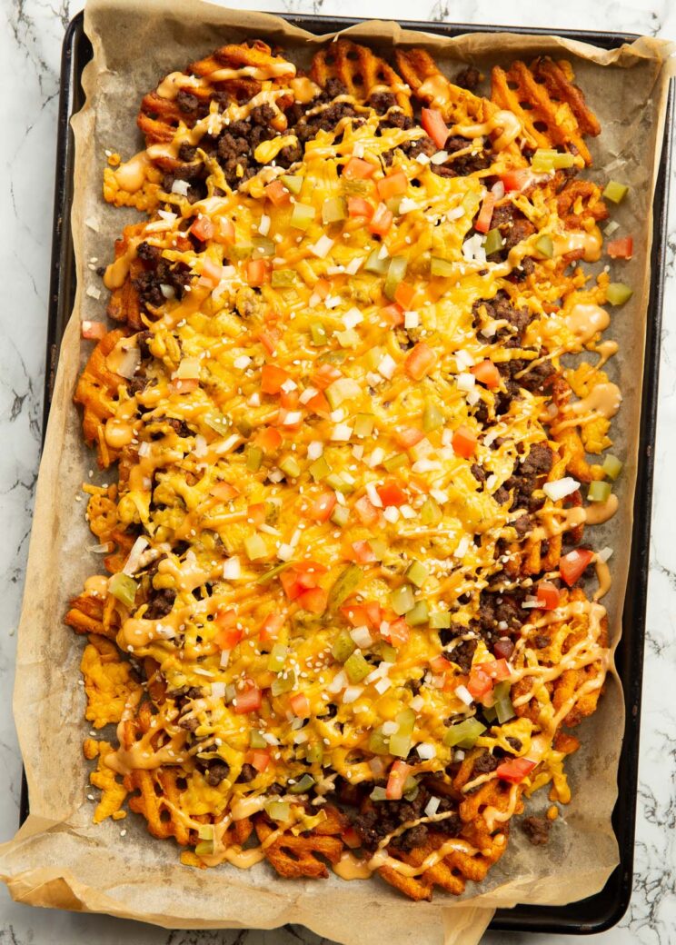 overhead shot of cheeseburger loaded fries on baking tray